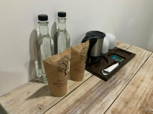 three bottles on a wooden table with a coffee maker at Wild Wadi Wilpattu - Villas with private Plunge Pools in Wilpattu