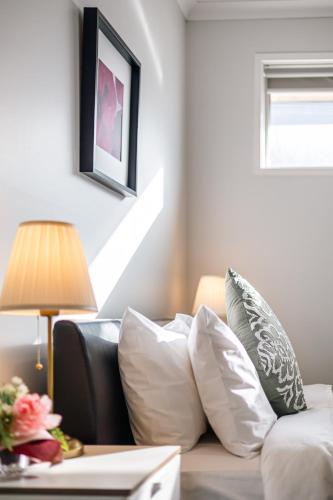 a living room with a couch with pillows and a lamp at Luxury Waterfront Villa in Sanctuary Lakes in Point Cook