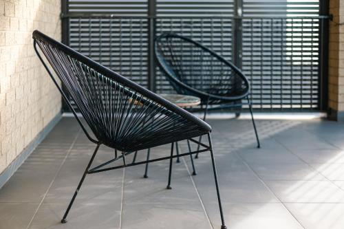 two black chairs sitting on a balcony at Luxury Waterfront Villa in Sanctuary Lakes in Point Cook