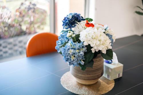 a vase filled with blue and white flowers on a table at Luxury Waterfront Villa in Sanctuary Lakes in Point Cook