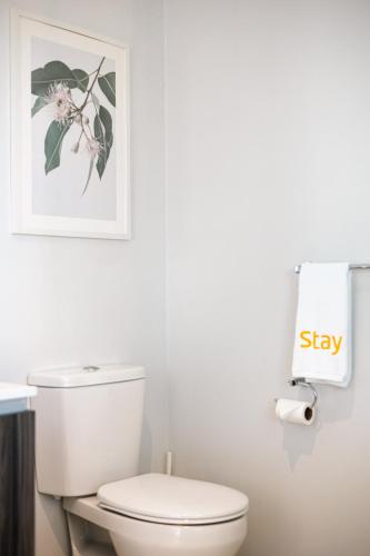 a bathroom with a white toilet and a picture on the wall at Luxury Waterfront Villa in Sanctuary Lakes in Point Cook