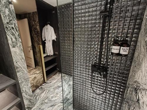 a shower with a glass door in a bathroom at Pentacity Hotel Balikpapan in Balikpapan