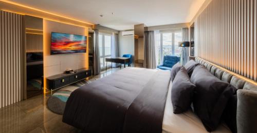 a hotel room with a large bed and a television at Pentacity Hotel Balikpapan in Balikpapan