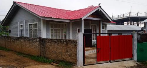 a house with a red roof and a fence at ovungs home in Yekhum