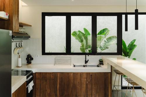 a kitchen with a sink and a window at Casa Amore 4BR Seminyak in Seminyak