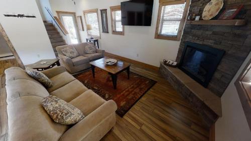 a living room with a couch and a fireplace at Lost in Paradise - Pet Friendly - Hot Tub - WiFi - Fireplace - Grill - On the River - Fire Pit in Red River