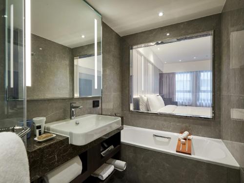 a bathroom with a sink and a large mirror at The Tango Hotel Taipei Linsen in Taipei