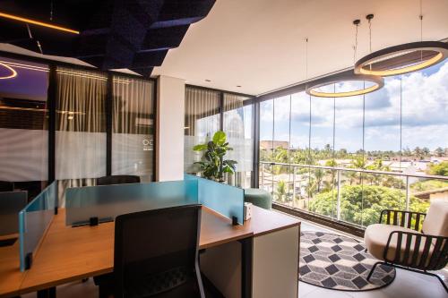 an office with a desk and a large window at Hotel Tango Suítes Cumbuco in Cumbuco