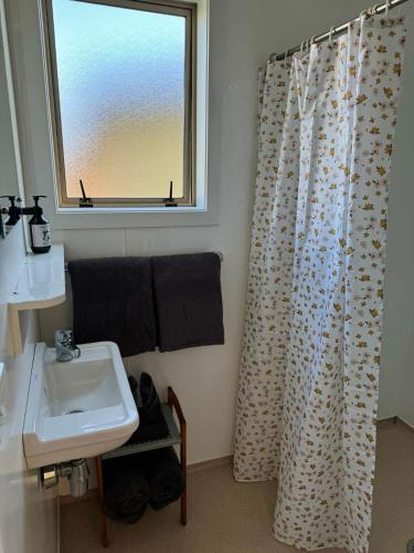 a bathroom with a sink and a shower curtain at Pohara Beach TOP 10 Holiday Park in Pohara