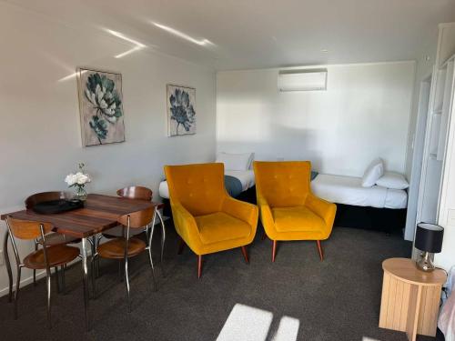 a room with a table and chairs and a bed at Pohara Beach TOP 10 Holiday Park in Pohara
