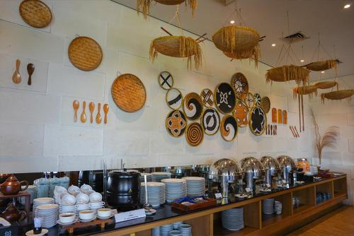 a counter with plates and utensils on a wall at BATIQA Hotel Palembang in Palembang