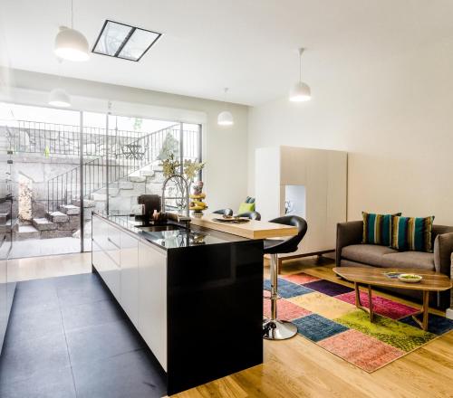 a kitchen and living room with a couch and a table at Oportolazaro Premium Downtown Porto in Porto