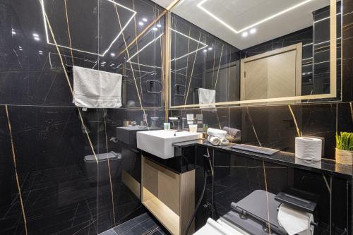 a black bathroom with a sink and a mirror at 1-Bed in Binghatti Crescent, Next to Circle Mall in Dubai