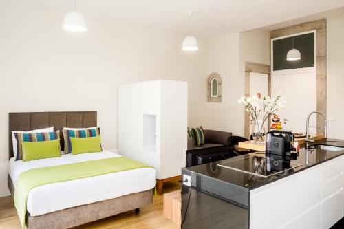 a hotel room with a bed and a kitchen at Oportolazaro Apartment in Porto