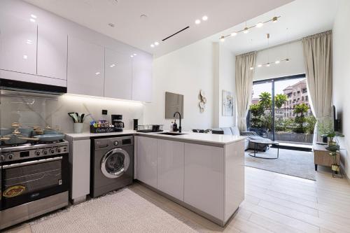 a kitchen with a stove and a dishwasher at 1-Bed in Binghatti Crescent, Next to Circle Mall in Dubai
