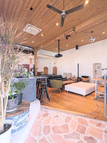 an open living room with a couch and tables at 港ノ宿 マルコ in Kami Amakusa