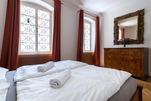 Un dormitorio con una cama blanca con dos toallas encima. en Historic Spirit at Studio under the Prague Castle, en Praga