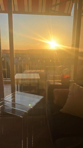 une vue du coucher de soleil depuis une pièce avec une table dans l'établissement Calm apartment with sea view, à Nice