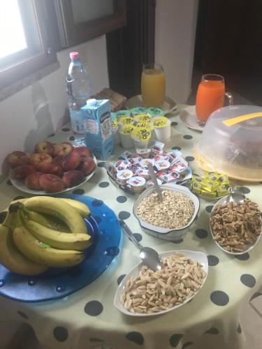 a table topped with bowls of cereal and fruit at Affittacamere Peonia in Oliena
