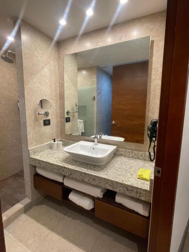 a bathroom with a sink and a large mirror at Hotel Sonata Angelopolis in Lomas de Angelopolis