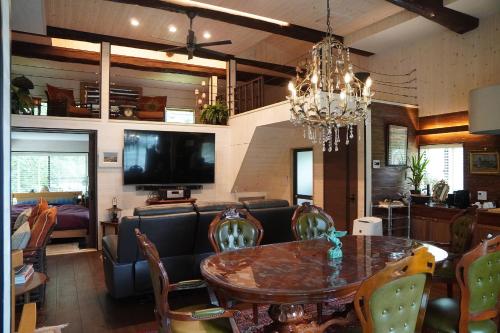 ein Wohnzimmer mit einem Esstisch und einem Kronleuchter in der Unterkunft Pond Cabin Myoko in Myōkō