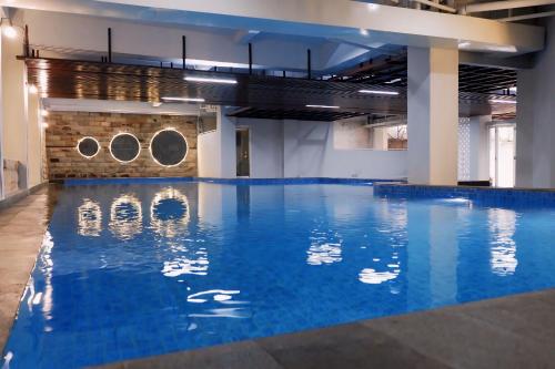 a large pool with blue water in a building at Hotel Grasia in Semarang