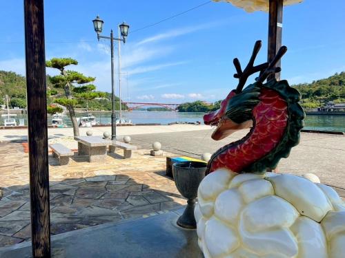a statue of a dragon sitting on top of a building at 港ノ宿 マルコ in Kami Amakusa
