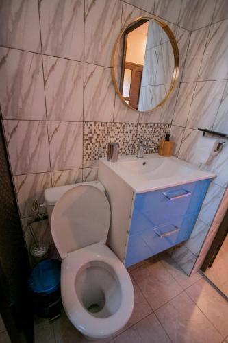 a bathroom with a toilet and a sink and a mirror at APPART Studio in Lomé