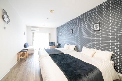 a bedroom with a large bed and a brick wall at Sunny Town-サニータウン- in Osaka