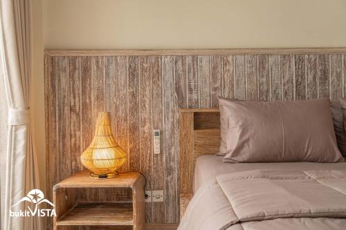 a bedroom with a bed and a lamp on a table at Kembang Kuning in Uluwatu