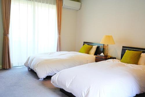 Ένα ή περισσότερα κρεβάτια σε δωμάτιο στο ヘレナ国際ヴィラ