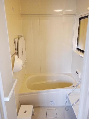a bath tub in a bathroom with a window at Sakurah in Sakura