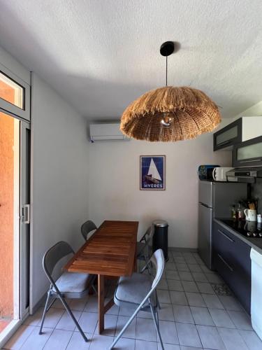 une salle à manger avec une table, des chaises et un lustre dans l'établissement La Bergerie, à Hyères