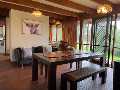 a living room with a wooden table and a couch at Willunga Cottage — Sweet Country Retreat in Lyndhurst South