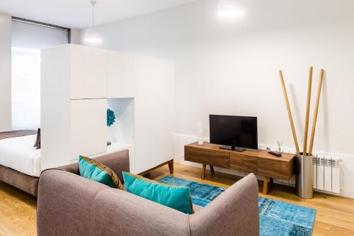 a living room with a couch and a tv at Oportolazaro Premium Downtown Porto in Porto