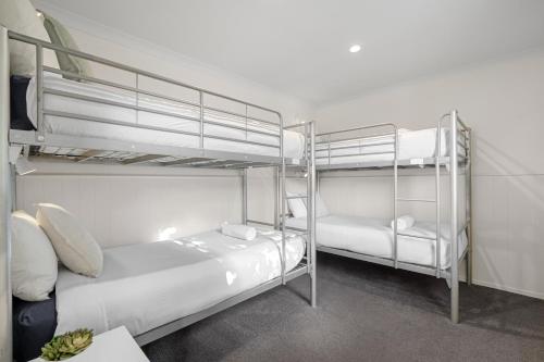 a room with two bunk beds and a desk at Tasman Holiday Parks Picton in Picton
