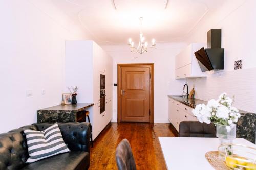 a kitchen and living room with a couch and a table at Cozy flat in Center in Maribor