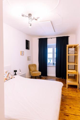 a bedroom with a white bed and blue curtains at Cozy flat in Center in Maribor