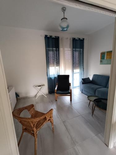 a living room with a blue couch and a chair at White Paestum in Paestum