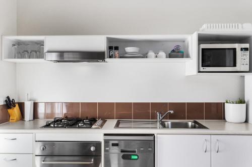 a kitchen with a sink and a microwave at The Point Villa in Cowes