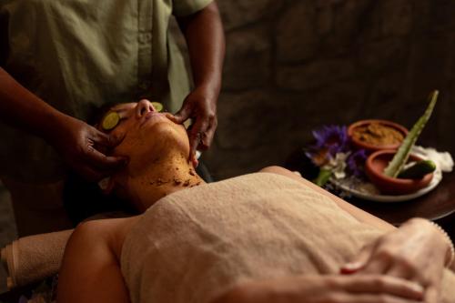 a man getting a head massage from a woman at Ayugiri Ayurveda Wellness Resort Sigiriya in Sigiriya