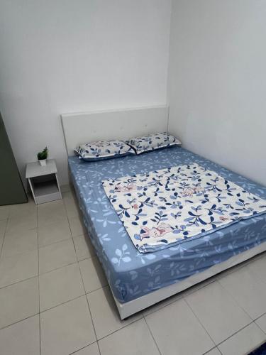 a bed in a room with a blue comforter and pillows at Ayaan Cozy Homestay Cameron Highland in Tanah Rata