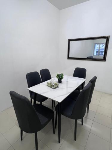 a white table with black chairs and a mirror at Ayaan Cozy Homestay Cameron Highland in Tanah Rata