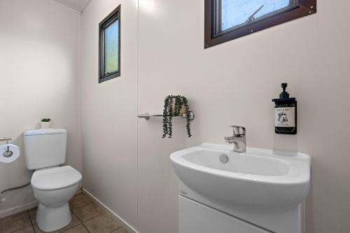 a white bathroom with a toilet and a sink at Tasman Holiday Parks Picton in Picton