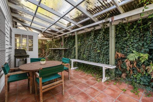 a patio with a green wall with a table and chairs at Tasman Holiday Parks Picton in Picton