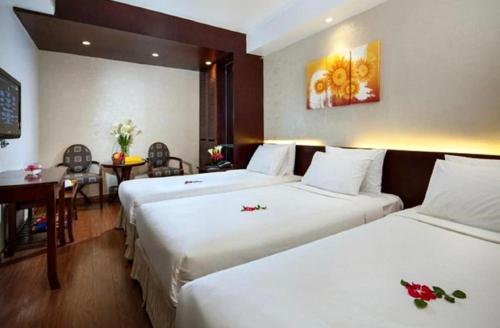 a hotel room with two beds and a table at Skylark Boutique Hotel in Hanoi