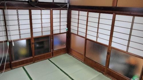 a room with three windows and a wall of windows at Snow Lepus Inn in Mizusawa