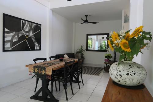 a dining room with a table and a vase of flowers at 2bd Legian Apartment 8 minutes to the beach in Seminyak