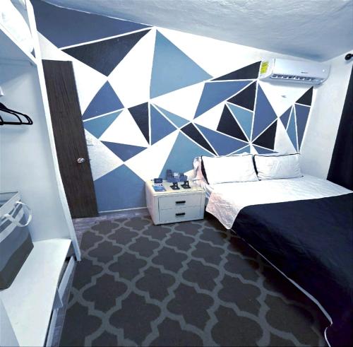 a bedroom with a blue and white wall at Hogar Pavo Real in Cancún