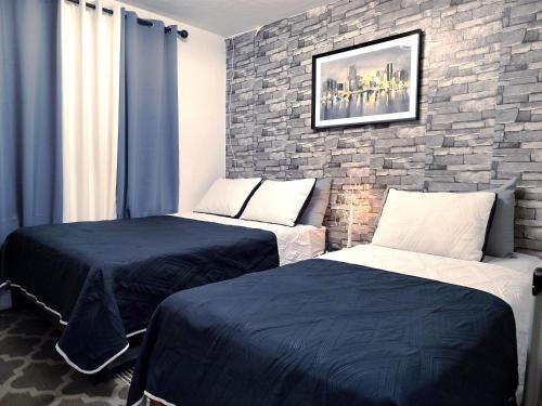 a bedroom with two beds and a brick wall at Hogar Pavo Real in Cancún